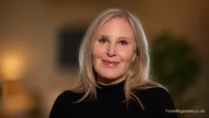 Carol Bryan close-up portrait with blonde hair and a black turtleneck, photographed against a soft blurred background.
